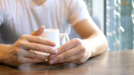 closeup. the man wears a wedding ring, sitting in a cafe.の写真素材