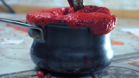 red froth pours out of the pan. making berry syrupの写真素材