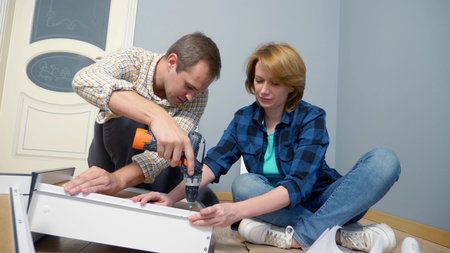 couple man and woman together install furniture in their apartment.