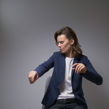 beautiful woman in business suit singing and dancing on gray backgroundの写真素材