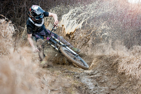 Mountainbiker rides on path in mudのeditorial素材