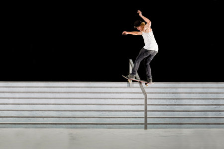 Boy doing skateboard trick on railの写真素材