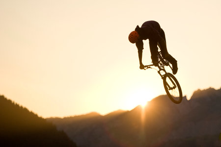Dirt jumping on sunset in mountainの写真素材