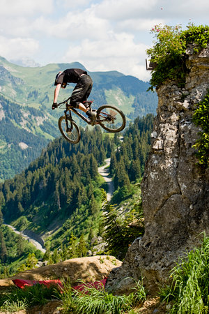 Mountainbiker jumping from a rockの写真素材