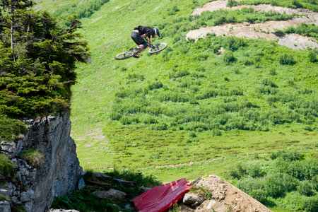 Mountainbiker jumping from a rocksの写真素材