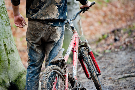 Mountainbiker and bike dirty with mudの写真素材