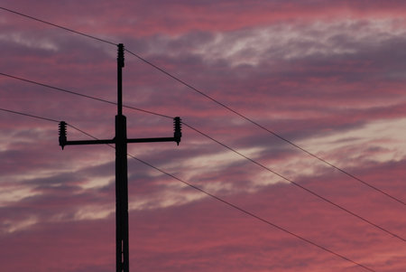 Electric pole on the background of the sunsetの写真素材