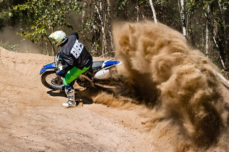 Motocross rider creates a large cloud of dust and debrisの写真素材