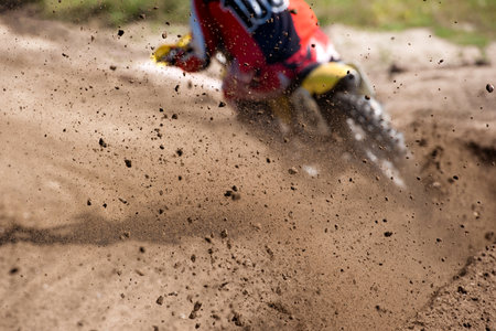 Motocross rider creates a large cloud of dust and debris