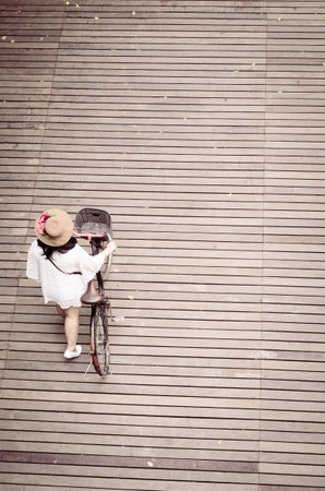 women and bicycle on the wooden floor vintage filterの写真素材