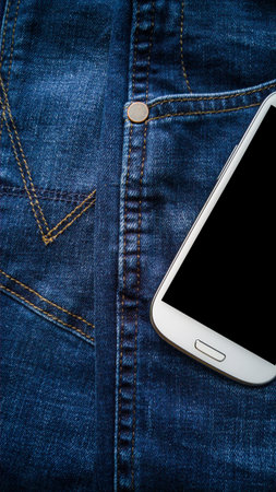Background of detail blue denim Jeans with back pocket white smart phoneの写真素材