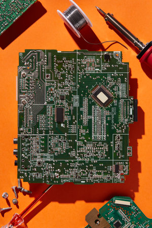Green circuit board isolated on orange background. Template with a copy spaceの写真素材
