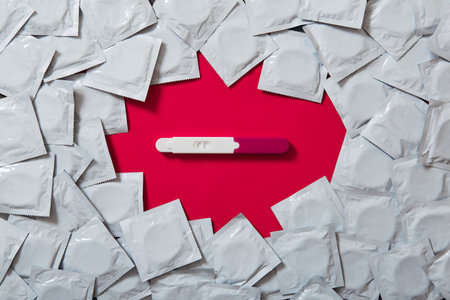 texture of many gray condoms and pregnancy test on the red background. Sex educationの写真素材