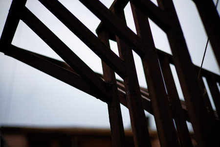 A professional low-angle shot of a modern architectural structure featuring parallel black metal...