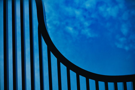 A professional low-angle shot of a modern architectural structure featuring parallel black metal...