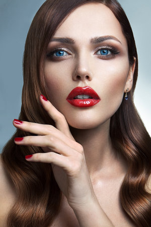 Portrait of beautiful girl with red lips and blue eyesの写真素材