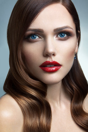 Portrait of beautiful girl with red lips and blue eyesの写真素材