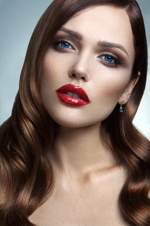 Portrait of beautiful girl with red lips and blue eyesの写真素材