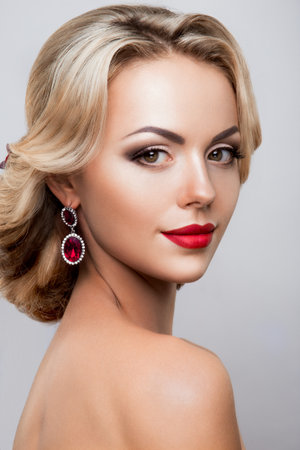Glamour portrait of beautiful woman model with fresh daily makeup and romantic wavy hairstyle. Fashion shiny highlighter on skin, sexy gloss lips make-up and dark eyebrowsの写真素材