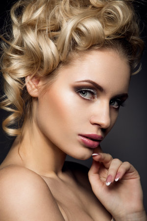 Glamour portrait of beautiful woman model with fresh daily makeup and romantic wavy hairstyle. Fashion shiny highlighter on skin, sexy gloss lips make-up and dark eyebrowsの写真素材