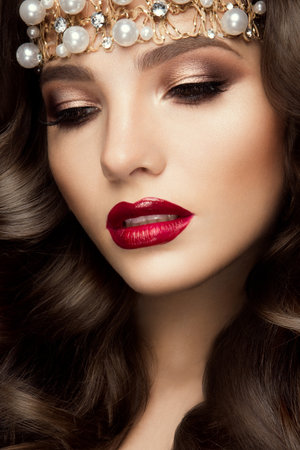 Beautiful young model with red lips and curly hairの写真素材