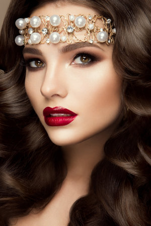 Beautiful young model with red lips and curly hairの写真素材