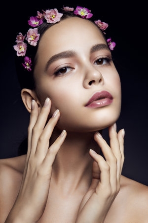 Beautiful girl with pink flowers. Clean skin.の写真素材
