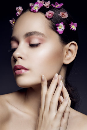Beautiful girl with pink flowers. Clean skin.の写真素材