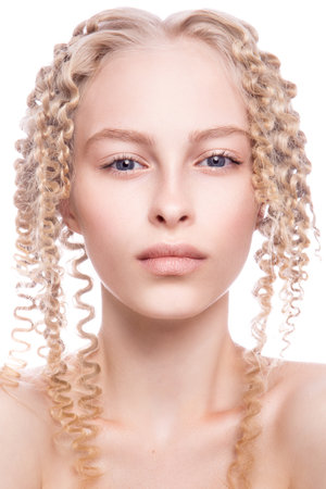 Portrait of a beautiful woman with curly blonde hair on white backgroundの写真素材