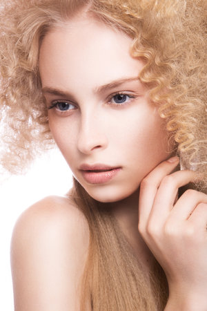 Portrait of a beautiful woman with curly blonde hair on white backgroundの写真素材