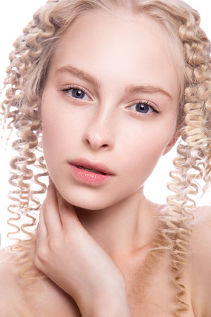 Portrait of a beautiful woman with curly blonde hair on white backgroundの写真素材