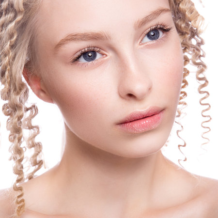 Portrait of a beautiful woman with curly blonde hair on white backgroundの写真素材