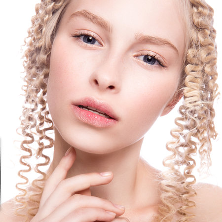Portrait of a beautiful woman with curly blonde hair on white backgroundの写真素材