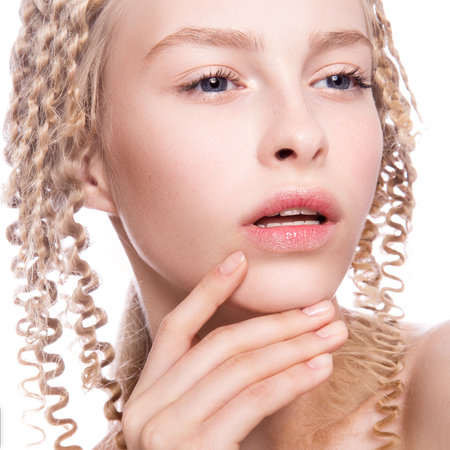 Portrait of a beautiful woman with curly blonde hair on white backgroundの写真素材