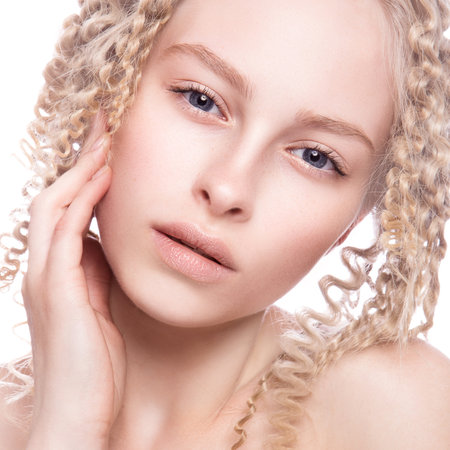 Portrait of a beautiful woman with curly blonde hair on white backgroundの写真素材