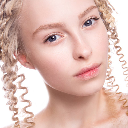 Portrait of a beautiful woman with curly blonde hair on white backgroundの写真素材