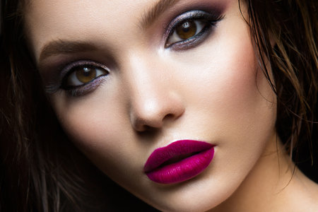 Beautiful young model with pink lips and dark makeapの写真素材
