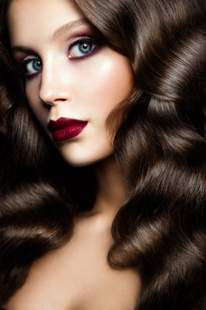 Girl with beautiful curly hair. Fashion portrait. Beautiful make up.の写真素材