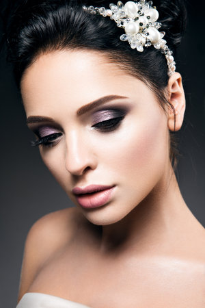Portrait of beautiful young woman with black hair and bright make-up, with accessoriesの写真素材