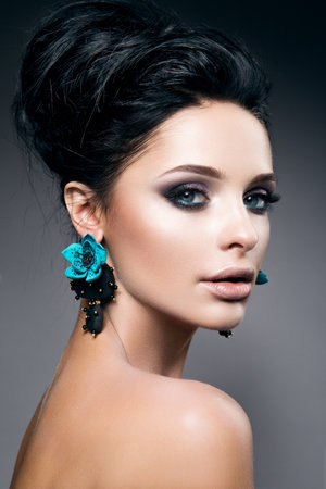 Portrait of beautiful young woman with black hair and bright make-up, with accessoriesの写真素材