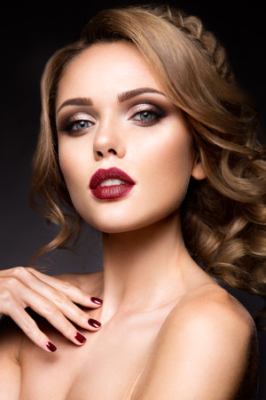 Close-up portrait of beautiful woman with bright make-up and dark red lipsの写真素材