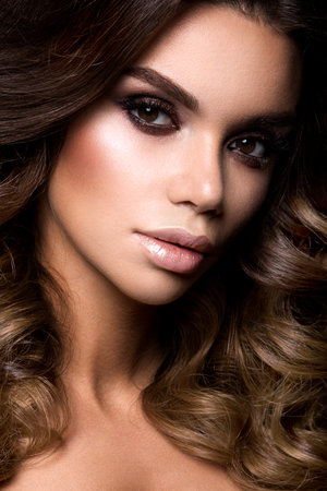 Close-up portrait of beautiful woman with bright make-up and curly hair.の写真素材