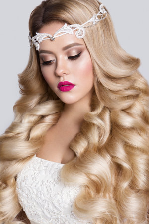 Beautiful young model with pink lips and curly hairの写真素材