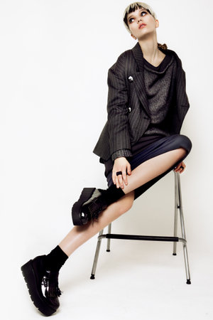 Beautiful young woman with long hair posing on wight background. Fashion clothes.の写真素材