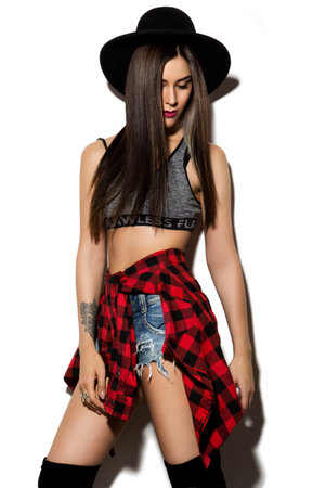 Beautiful young woman with long hair posing on wight background. Black hat.の写真素材