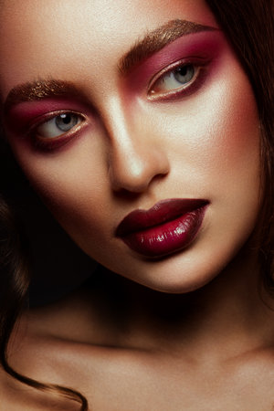 Close-up portrait of beautiful woman with bright make-up and hairstyle.の写真素材