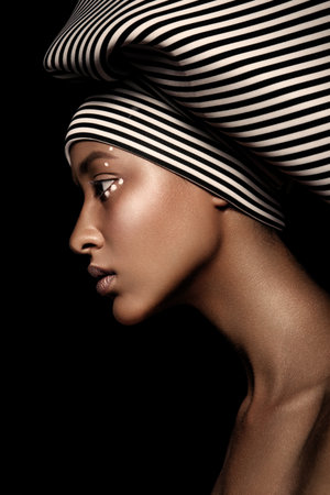 young beautiful fashion model with scarf and makeup on dark background.の写真素材