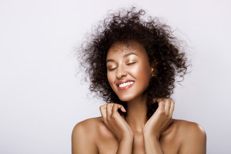 Fashion studio portrait of beautiful african american woman with perfect smooth glowing mulatto skin, make upの写真素材
