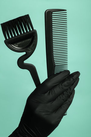 Composition with scissors and other hairdresser's accessories on green background, top view