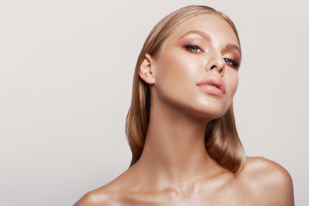 Beauty portrait of model with natural make-up. Fashion shiny highlighter on skin, sexy gloss lips make-upの写真素材